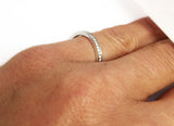 18Kt White Gold Bead Prong Set Diamond Narrow Band at Rubini Jewelers, shown on woman's hand