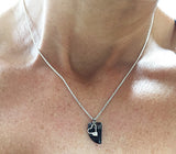 Black Stone and Silver Rowing Heart Necklace by Rubini Jewelers, shown on neck