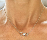 Silver Rowing Infinity with Sapphire Necklace by Rubini Jewelers, shown on neck